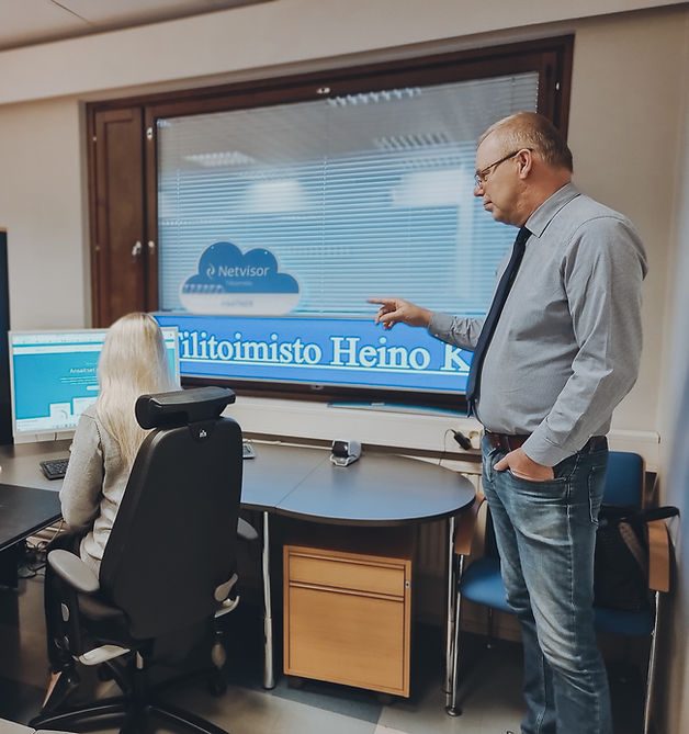 Neuvottelu toimistossa suuren näytön äärellä